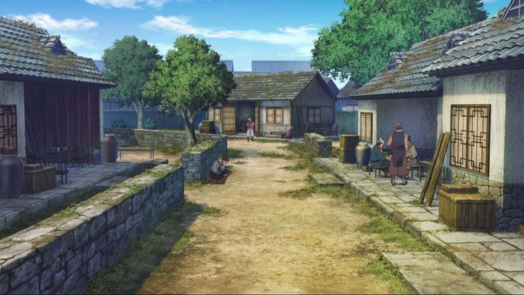 Ein Feldweg mit kleinen Häusern am Rande.