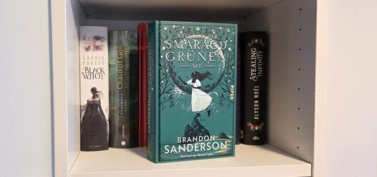 Ein Regal mit Büchern: Im Hintergrund sieht man einige Fantasy Romane stehen und im Vordergrund befindet sich das Buch „Weit über der Smaragdgrünen See" von Brandon Sanderson.