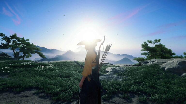 Screenshot aus dem PlayStation 5 Game: Ghost of Yotei. Die Protagonistin steht mitten auf einer Wiese, die Sonne strahlt sie an und lässt die Umrisse leicht verblassen.